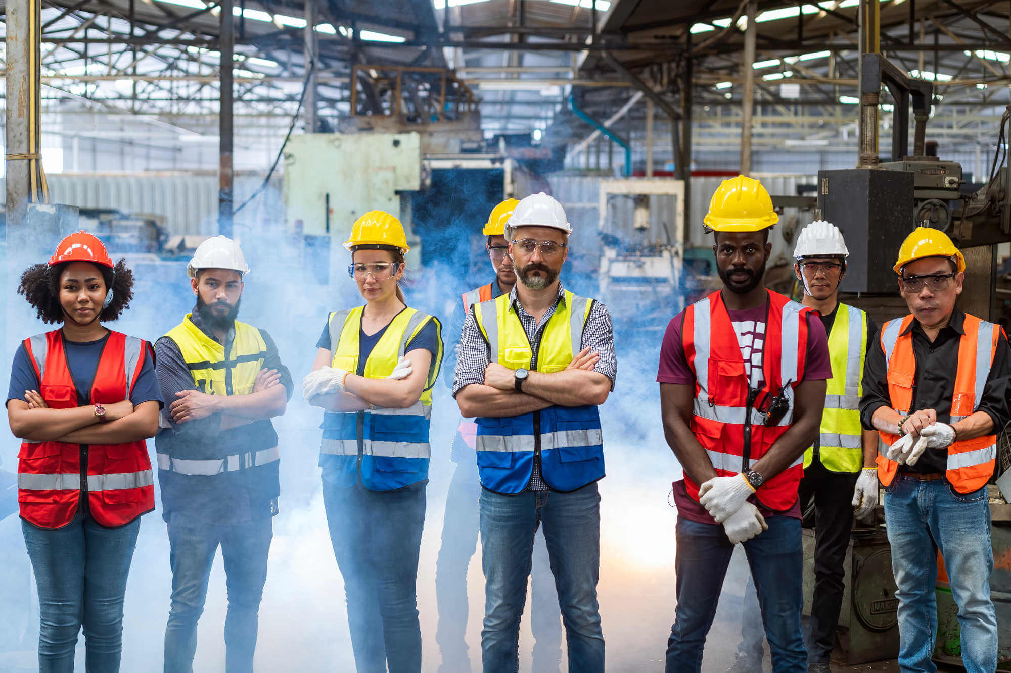 Team in hi-vis safety gear standing in engineering factory